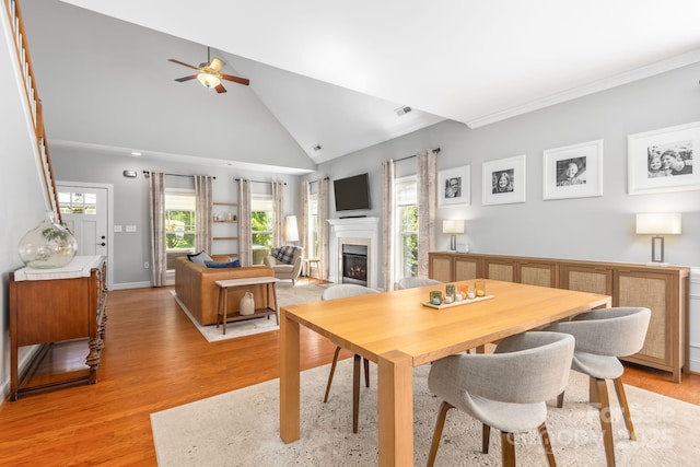 516 King St, Waxhaw, NC 28173 - dining area featuring a ceiling fan, a lit fireplace, healthy amount of natural light, light wood-style floors, and high vaulted ceiling