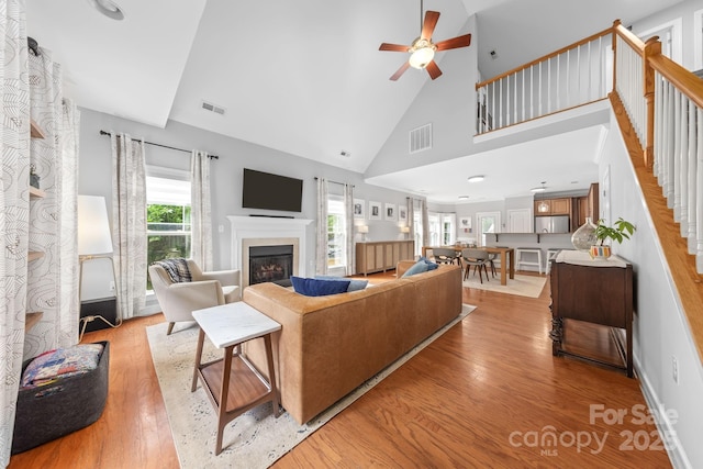 516 King St, Waxhaw, NC 28173 - living room featuring a glass covered fireplace, a ceiling fan, light wood-type flooring, and high vaulted ceiling
