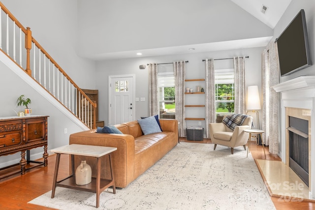 516 King St, Waxhaw, NC 28173 - living area featuring stairway, a fireplace with flush hearth, wood finished floors, high vaulted ceiling, and recessed lighting
