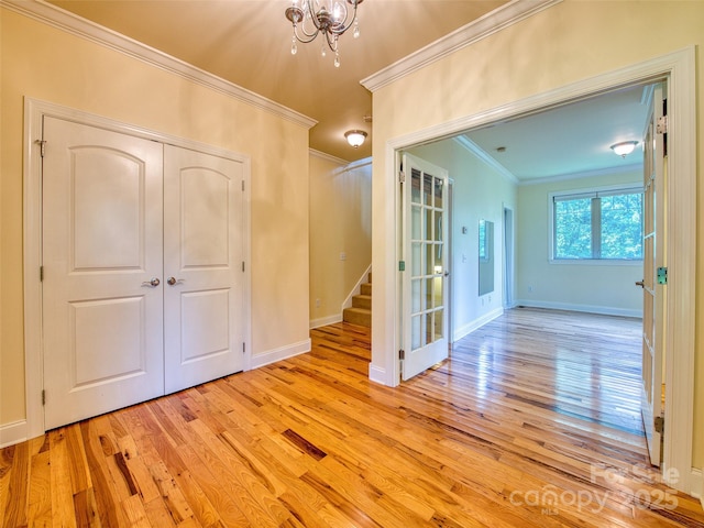 20A Lila Ln, Clyde, NC 28721 - spare room with crown molding, light wood finished floors, stairs, a chandelier, and baseboards