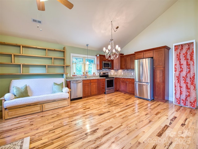 20A Lila Ln, Clyde, NC 28721 - kitchen with appliances with stainless steel finishes, light wood-style floors, a chandelier, pendant lighting, and backsplash