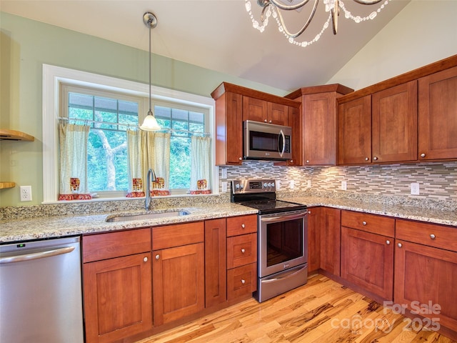 20A Lila Ln, Clyde, NC 28721 - kitchen with appliances with stainless steel finishes, a sink, tasteful backsplash, light wood-style floors, and brown cabinetry