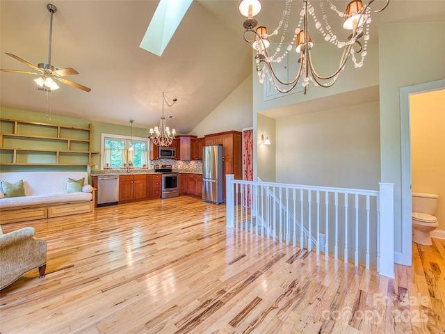 20A Lila Ln, Clyde, NC 28721 - kitchen with stainless steel appliances, a chandelier, brown cabinets, decorative backsplash, and open floor plan