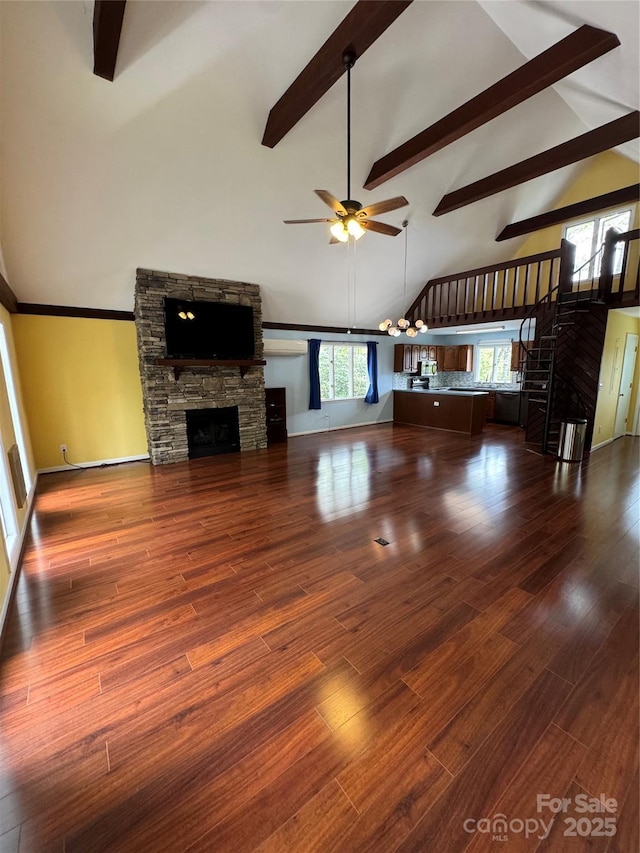 365 Trout Brook Loop, Newland, NC 28657 - unfurnished living room with a stone fireplace, a ceiling fan, beamed ceiling, high vaulted ceiling, and wood finished floors
