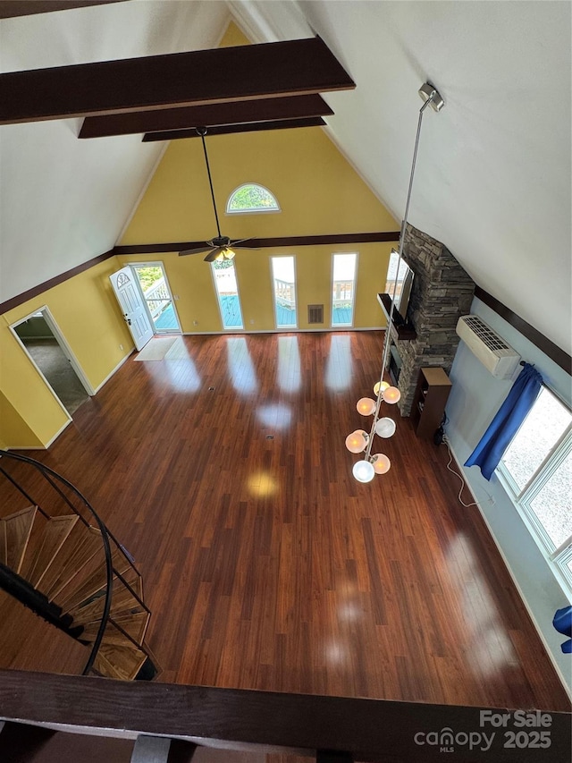 365 Trout Brook Loop, Newland, NC 28657 - unfurnished living room with healthy amount of natural light, beam ceiling, wood finished floors, a ceiling fan, and high vaulted ceiling
