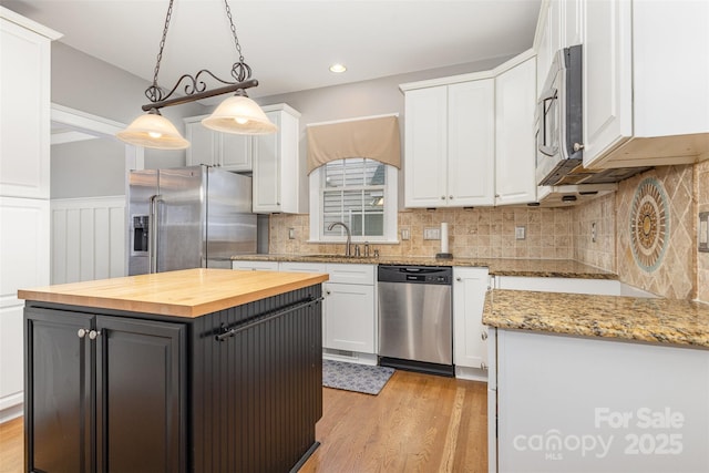 3906 Balsam St, Indian Trail, NC 28079 - kitchen with appliances with stainless steel finishes, butcher block counters, white cabinetry, a sink, and light wood finished floors