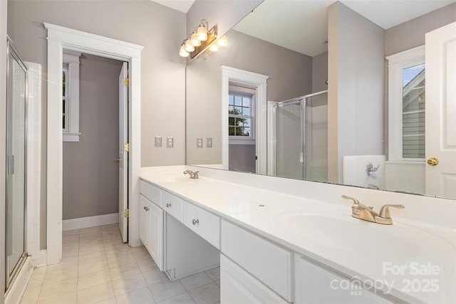 3906 Balsam St, Indian Trail, NC 28079 - bathroom featuring a stall shower, double vanity, tile patterned flooring, and baseboards