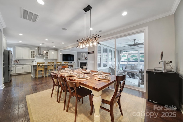 11216 Preservation Ln, Charlotte, NC 28278 - dining space with dark wood-type flooring, crown molding, ceiling fan, and recessed lighting