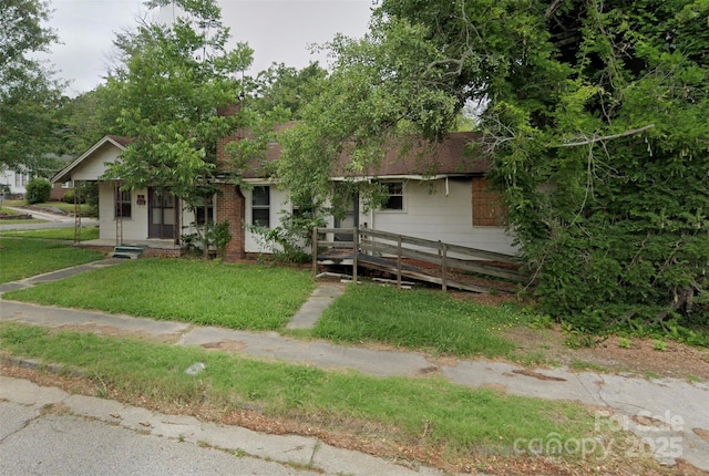 view of property hidden behind natural elements with a front lawn