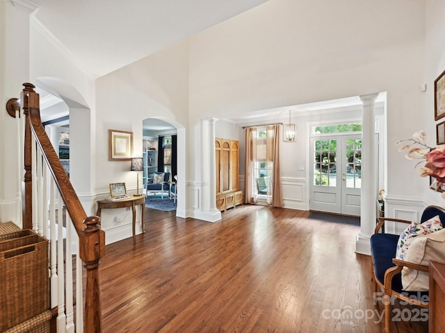 18419 Dembridge Dr, Davidson, NC 28036 - entryway with ornate columns, a decorative wall, arched walkways, wood finished floors, and a towering ceiling