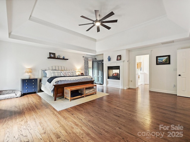 18419 Dembridge Dr, Davidson, NC 28036 - bedroom featuring a tray ceiling, wood finished floors, baseboards, and ceiling fan