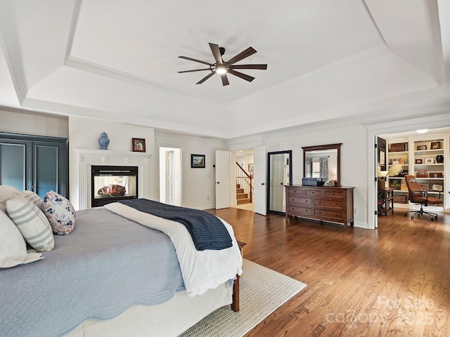 18419 Dembridge Dr, Davidson, NC 28036 - bedroom with a raised ceiling, wood finished floors, a multi sided fireplace, and baseboards