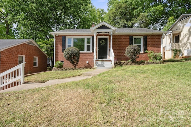 534 W Kingston Ave, Charlotte, NC 28203 - view of front of house featuring brick siding, a front lawn, entry steps, and a chimney