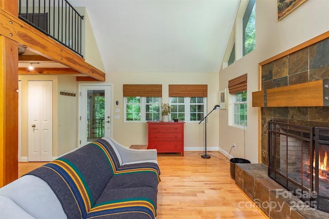 7 Western View St, Black Mountain, NC 28711 - living room with light wood-style flooring, a tiled fireplace, high vaulted ceiling, and baseboards