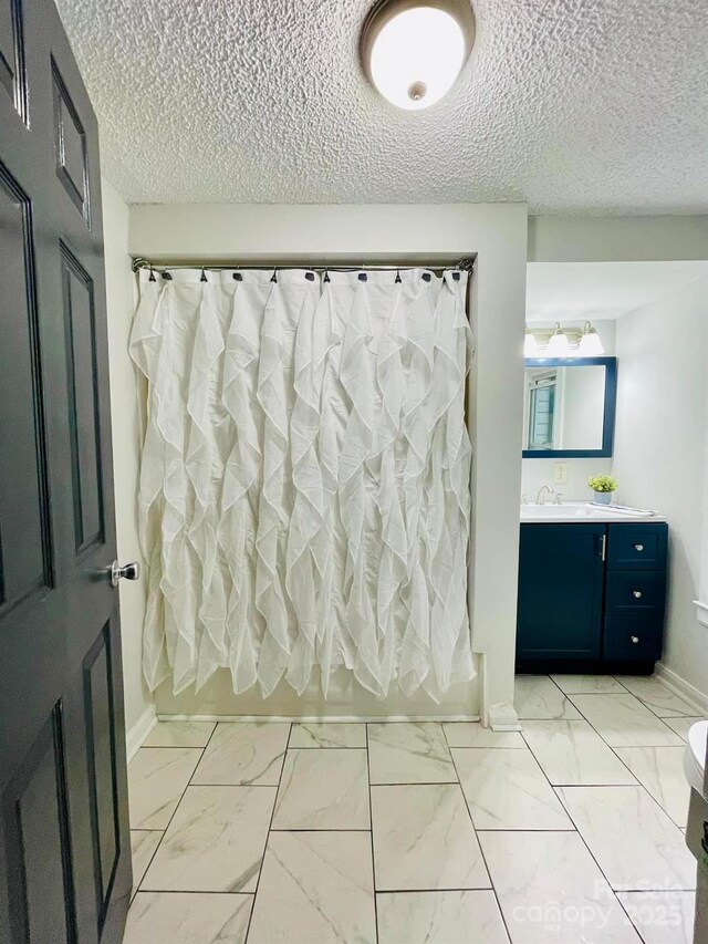 357 Huger St, Cheraw, SC 29520 - full bathroom featuring marble finish floors, shower / bathtub combination with curtain, a textured ceiling, baseboards, and vanity