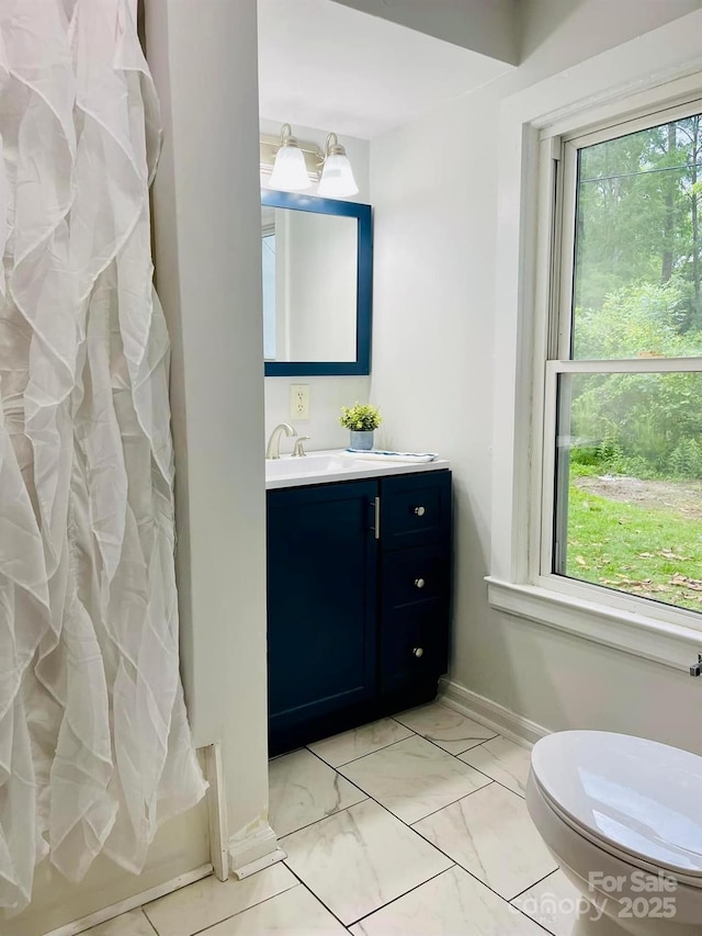 357 Huger St, Cheraw, SC 29520 - bathroom with plenty of natural light, toilet, vanity, and baseboards