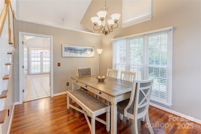 dining room featuring a chandelier, wood finished floors, baseboards, and high vaulted ceiling