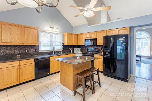 kitchen featuring black appliances, a sink, a center island, light tile patterned floors, and decorative backsplash