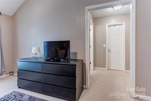 bedroom with carpet floors, baseboards, and a textured ceiling
