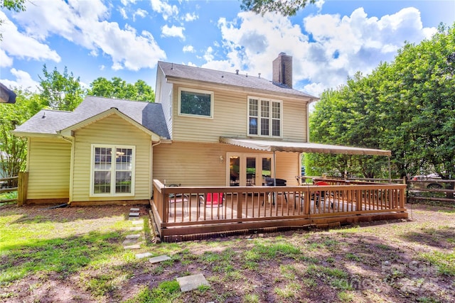 back of property with a chimney, a deck, fence, and french doors