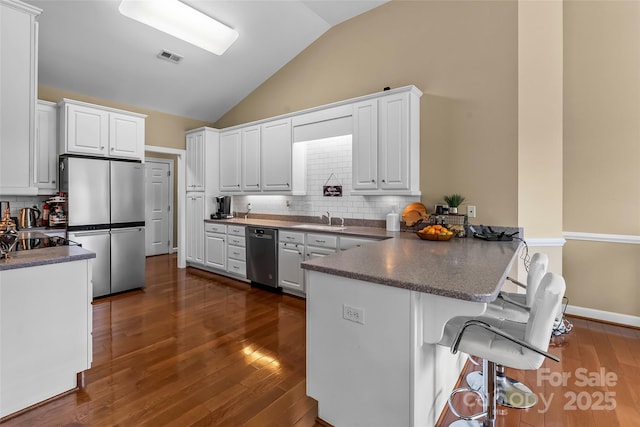1825 Smyre Farm Rd, Newton, NC 28658 - kitchen with stainless steel appliances, a peninsula, white cabinets, backsplash, and dark countertops