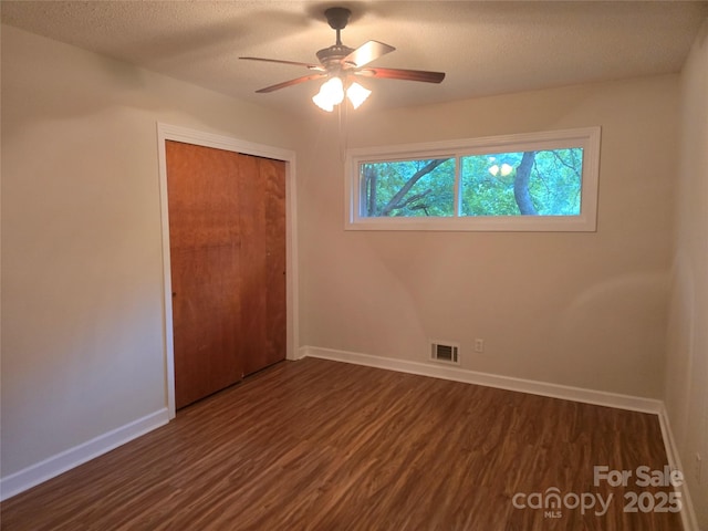 520 Crestview Dr, Albemarle, NC 28001 - unfurnished bedroom featuring dark wood-type flooring, a closet, baseboards, a textured ceiling, and a ceiling fan