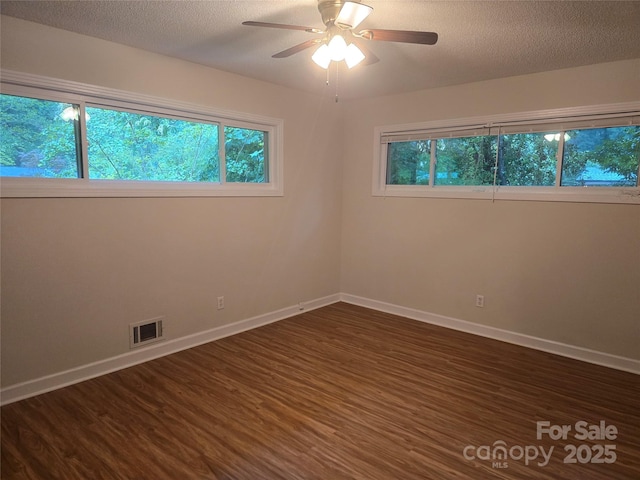 520 Crestview Dr, Albemarle, NC 28001 - empty room featuring dark wood finished floors, plenty of natural light, baseboards, and a textured ceiling