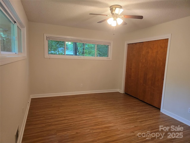 520 Crestview Dr, Albemarle, NC 28001 - unfurnished bedroom with wood finished floors, a closet, baseboards, a textured ceiling, and a ceiling fan