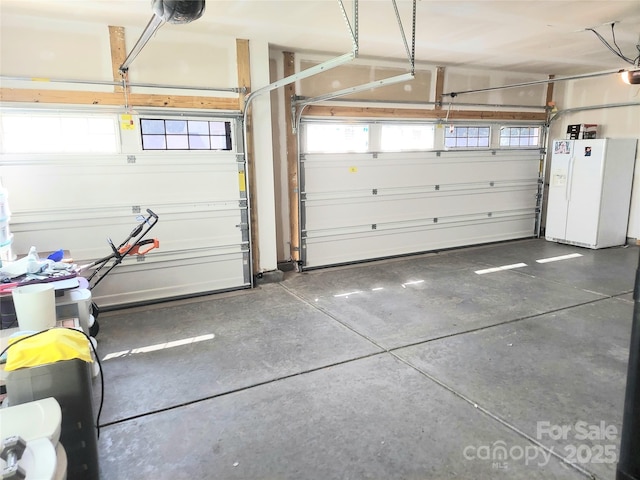 2061 Argentum Ave, Fort Mill, SC 29707 - garage with white refrigerator with ice dispenser and a garage door opener