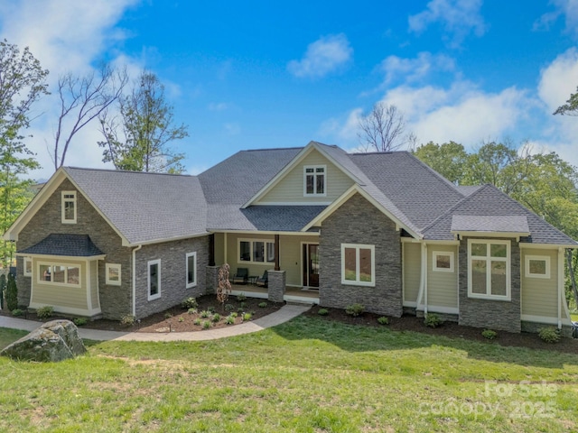 128 Saddle Ridge Dr, Alexander, NC 28701 - craftsman house featuring stone siding, a front lawn, a shingled roof, and covered porch