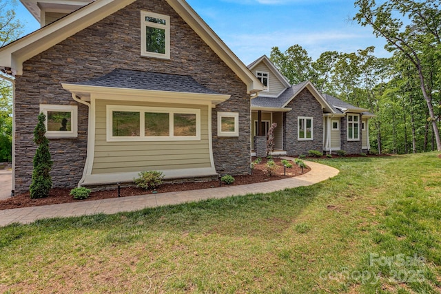 128 Saddle Ridge Dr, Alexander, NC 28701 - craftsman-style home featuring stone siding, a front yard, and roof with shingles