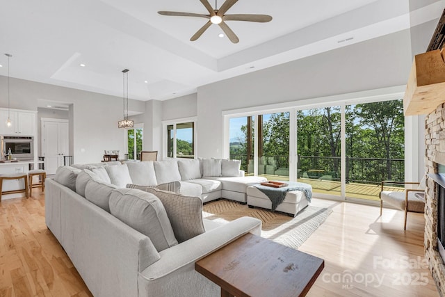 128 Saddle Ridge Dr, Alexander, NC 28701 - living area featuring a ceiling fan, a tray ceiling, light wood-type flooring, a fireplace, and recessed lighting