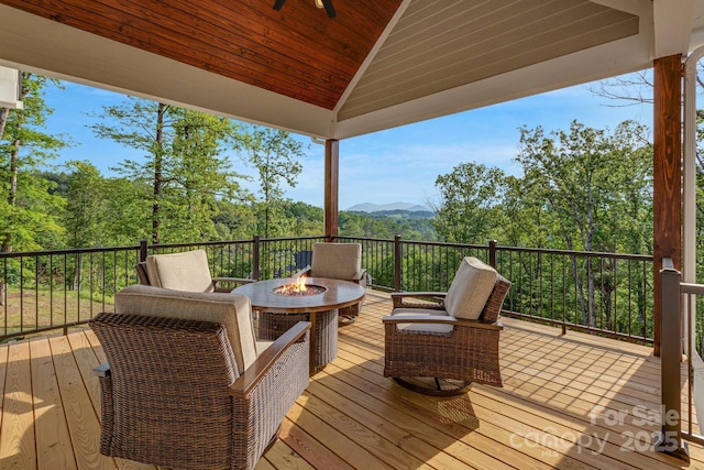 128 Saddle Ridge Dr, Alexander, NC 28701 - deck with a fire pit, ceiling fan, a mountain view, and a forest view