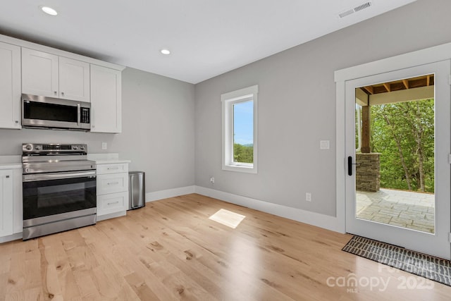 128 Saddle Ridge Dr, Alexander, NC 28701 - kitchen with stainless steel appliances, white cabinets, light countertops, light wood-type flooring, and recessed lighting