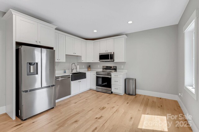 128 Saddle Ridge Dr, Alexander, NC 28701 - kitchen with appliances with stainless steel finishes, light countertops, light wood-style floors, recessed lighting, and white cabinetry