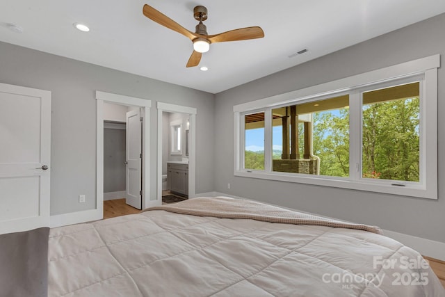 128 Saddle Ridge Dr, Alexander, NC 28701 - bedroom with a spacious closet, light wood finished floors, recessed lighting, a ceiling fan, and ensuite bath