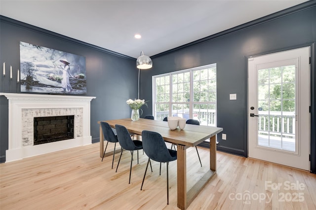 dining area with a fireplace, wood finished floors, ornamental molding, and recessed lighting