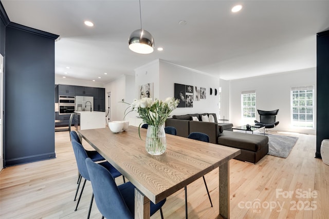 dining area with light wood-style floors, ornamental molding, and recessed lighting