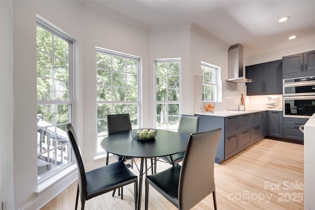 dining area featuring light wood finished floors, recessed lighting, and crown molding