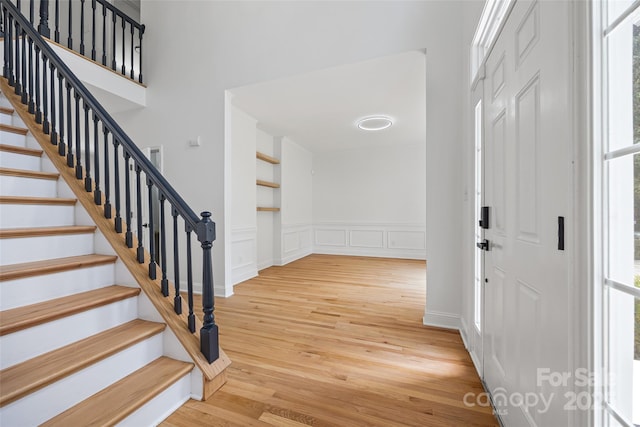 1134 Blueberry Ln, Charlotte, NC 28226 - entryway featuring wood finished floors, plenty of natural light, stairway, a decorative wall, and wainscoting