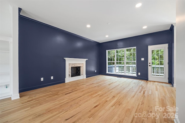 1134 Blueberry Ln, Charlotte, NC 28226 - unfurnished living room with light wood-style flooring, crown molding, recessed lighting, and a fireplace