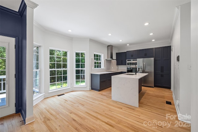 1134 Blueberry Ln, Charlotte, NC 28226 - kitchen with appliances with stainless steel finishes, crown molding, wall chimney exhaust hood, light countertops, and light wood-style floors