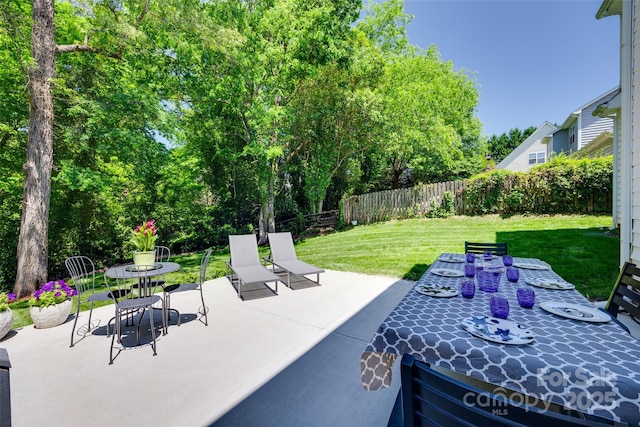 1134 Blueberry Ln, Charlotte, NC 28226 - fenced backyard featuring outdoor dining space, a patio, and view of scattered trees
