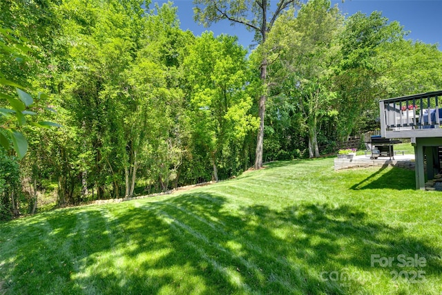 1134 Blueberry Ln, Charlotte, NC 28226 - view of grassy yard featuring a wooden deck and a wooded view