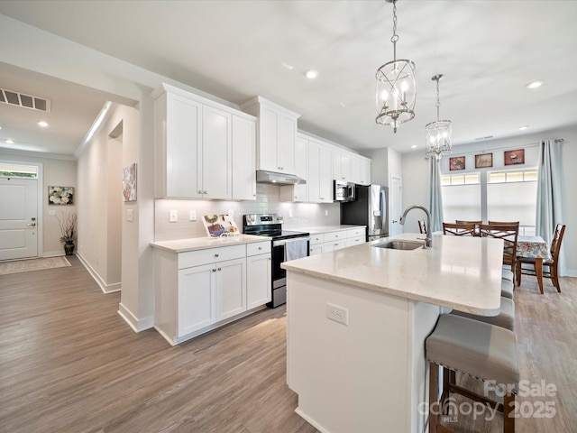 1456 Augustus Beamon Dr, Indian Trail, NC 28079 - kitchen with appliances with stainless steel finishes, under cabinet range hood, a sink, a kitchen island with sink, and baseboards