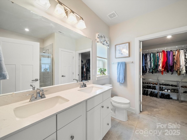 1456 Augustus Beamon Dr, Indian Trail, NC 28079 - bathroom featuring a shower stall, a walk in closet, double vanity, toilet, and baseboards