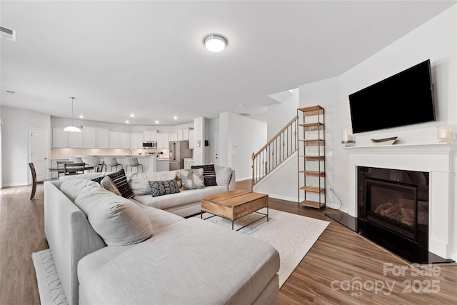 15630 Oleander Dr, Charlotte, NC 28278 - living area with stairs, wood finished floors, baseboards, recessed lighting, and a glass covered fireplace