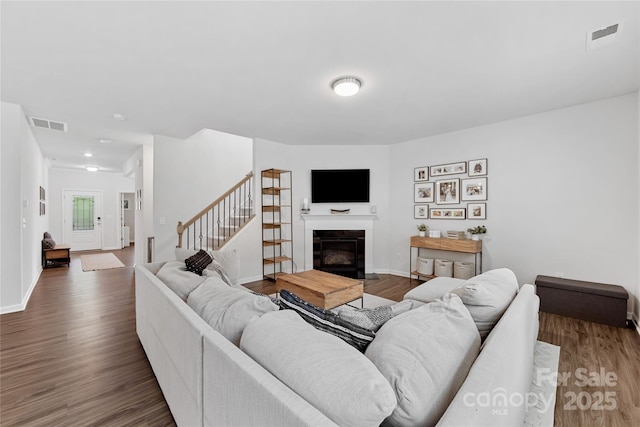 15630 Oleander Dr, Charlotte, NC 28278 - living room with wood finished floors, stairs, a fireplace with flush hearth, and baseboards