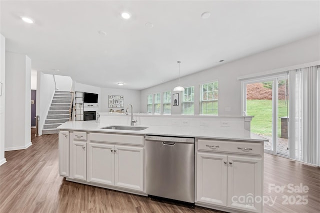 15630 Oleander Dr, Charlotte, NC 28278 - kitchen featuring a sink, dishwasher, open floor plan, light countertops, and light wood-style flooring