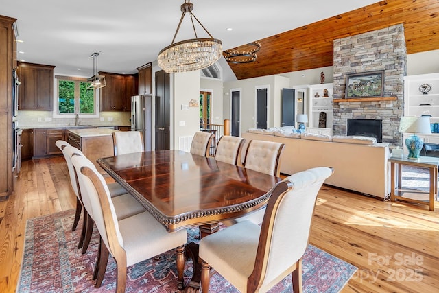204 Ridge Dr Unit 12 12-1 12-2, Troy, NC 27371 - dining space featuring a chandelier, light wood-style floors, lofted ceiling, a fireplace, and recessed lighting